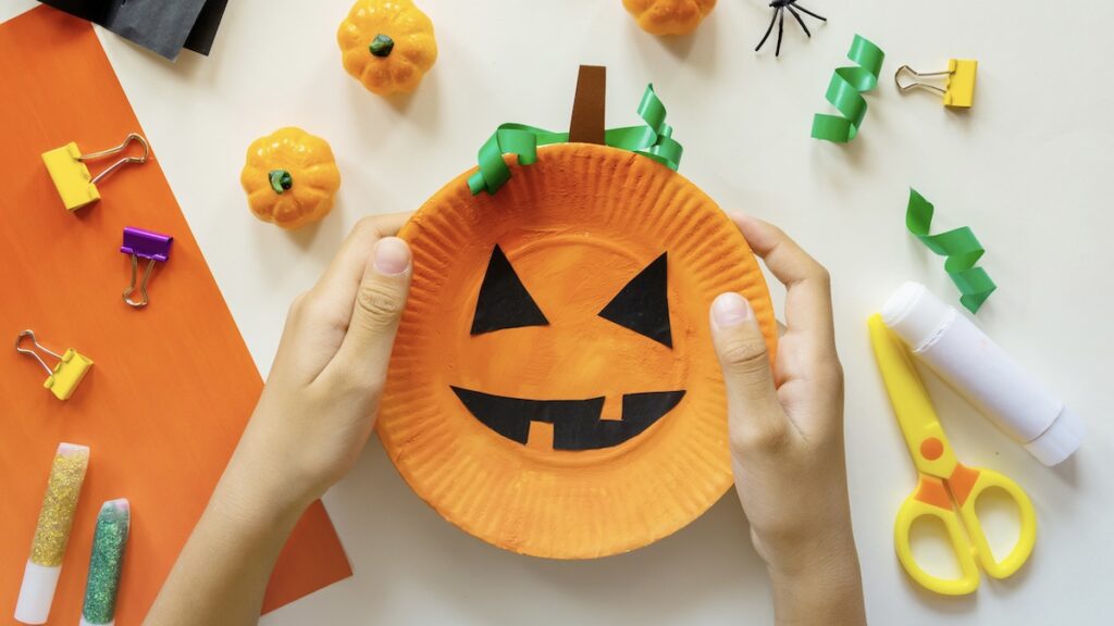 Cuts of paper for Halloween. Hand cut paper. Pumpkins. Scissors and glue. On a light background. Top view. Flat lay.