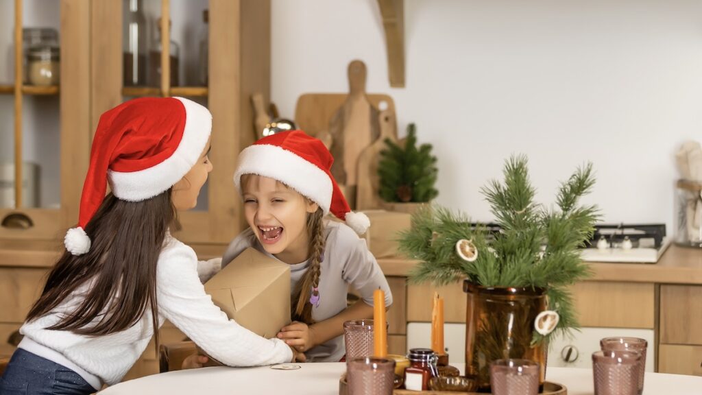 One of 10 Fun Christmas Activities for Kids to Make the Season Magical- Two happy little girls found a treasure at the end of Christmas scavenger hunt